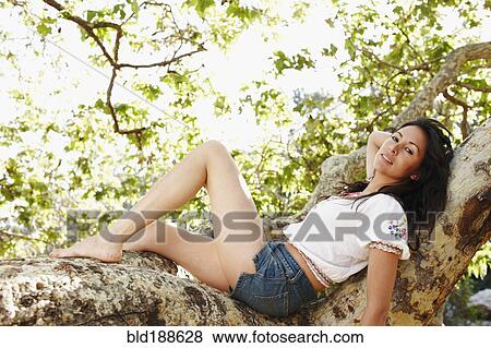 Hispanic woman laying on tree branch View Large Photo Image Stock Photo - Hispanic woman laying on tree branch. Fotosearch