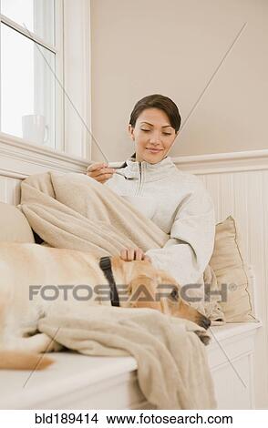 Picture - Hispanic woman petting dog. Fotosearch