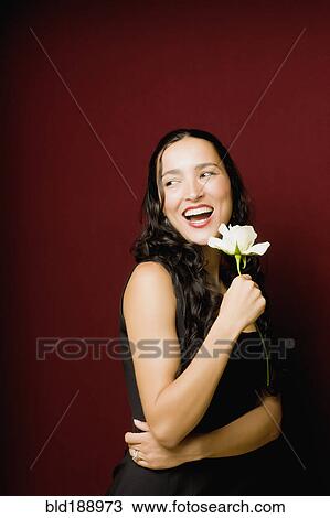 Stock Image - Hispanic woman posing with white rose. Fotosearch