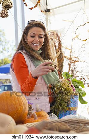 Picture - Hispanic woman shopping at farmer's market. Fotosearch