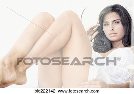 Stock Image - Hispanic woman sitting in chair. Fotosearch