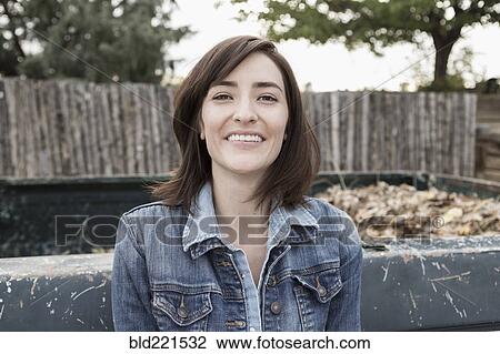 Stock Image - Hispanic woman smiling at truck. Fotosearch