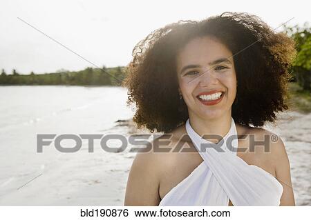 Stock Photograph - Hispanic woman smiling near ocean. Fotosearch