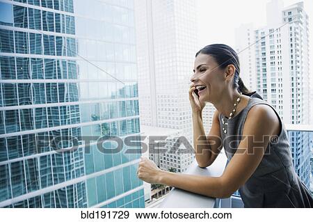 Hispanic woman talking on cell phone on urban balcony View Large Photo Image Stock Photo - Hispanic woman talking on cell phone on urban balcony. Fotosearch