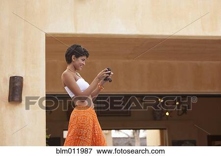 Hispanic woman using digital camera View Large Photo Image Stock Photo - Hispanic woman using digital camera. Fotosearch