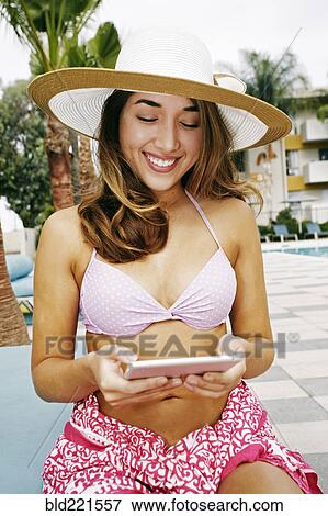 Stock Photo - Hispanic woman using digital tablet outdoors. Fotosearch