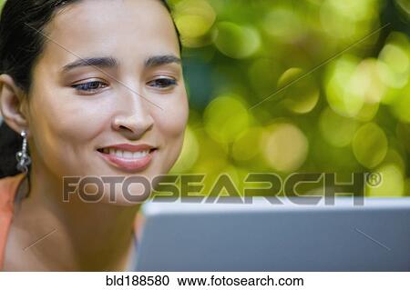 Stock Image - Hispanic woman using laptop. Fotosearch