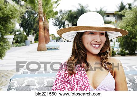 Stock Image - Hispanic woman wearing sun hat outdoors. Fotosearch