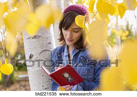 Stock Photography - Hispanic woman writing in tree. Fotosearch