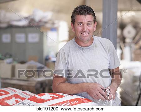 Hispanic worker holding bag in factory warehouse View Large Photo Image Stock Image - Hispanic worker holding bag in factory warehouse. Fotosearch