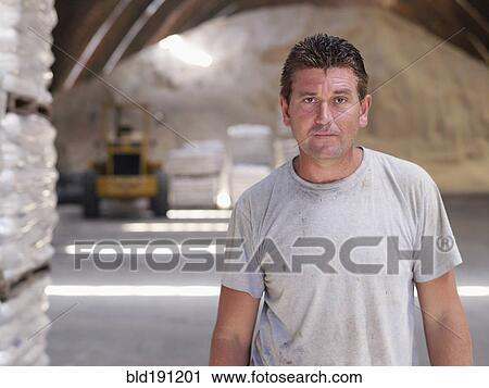 Stock Image - Hispanic worker in factory warehouse. Fotosearch