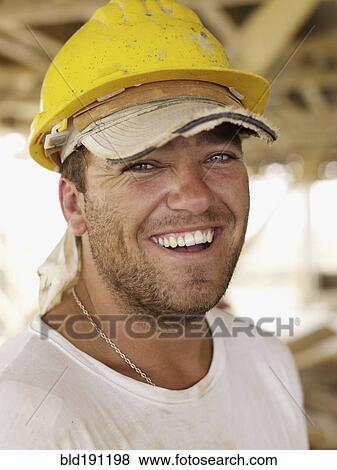 Stock Photo - Hispanic worker smiling on construction site. Fotosearch