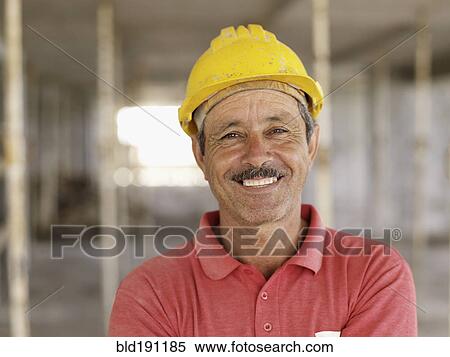 Hispanic worker smiling on construction site View Large Photo Image Stock Photography - Hispanic worker smiling on construction site. Fotosearch