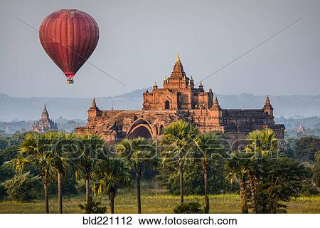 Hot air balloon flying over temple View Large Photo Image Stock Image - Hot air balloon flying over temple. Fotosearch