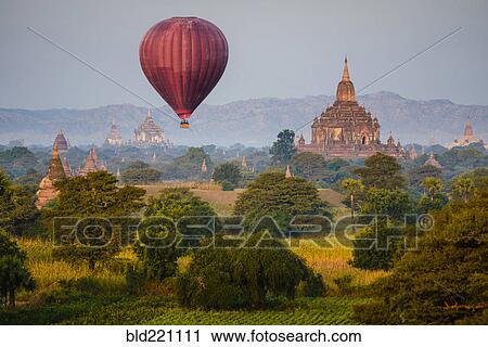 Hot air balloon flying over towers View Large Photo Image Stock Image - Hot air balloon flying over towers. Fotosearch