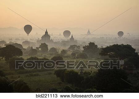 Hot air balloons flying over towers View Large Photo Image Stock Image - Hot air balloons flying over towers. Fotosearch