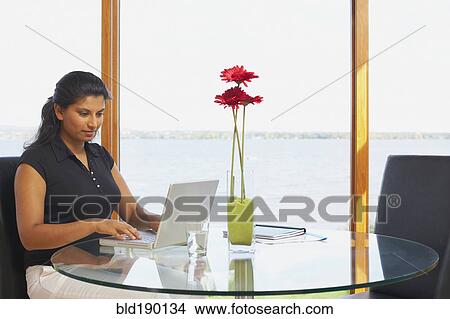 Picture - Indian woman typing on laptop. Fotosearch