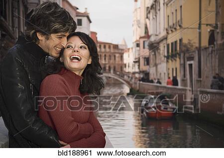 Stock Image - Italian couple hugging near canal. Fotosearch