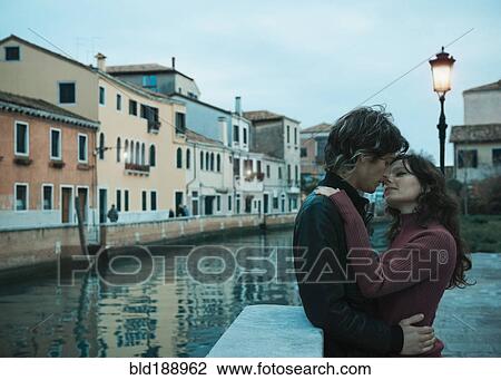 Stock Image - Italian couple kissing near canal. Fotosearch