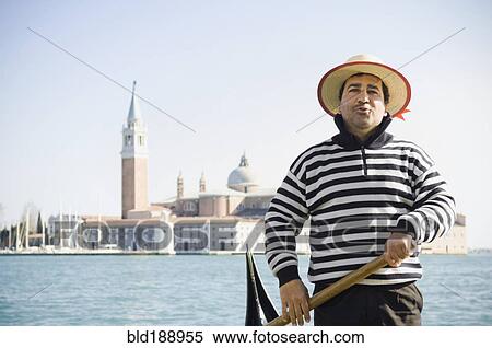 Stock Photography - Italian gondolier with church in background. Fotosearch