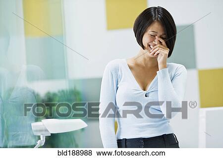 Japanese businesswoman laughing in office View Large Photo Image Stock Photo - Japanese businesswoman laughing in office. Fotosearch