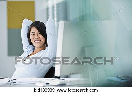 Stock Photo - Japanese businesswoman sitting in office. Fotosearch