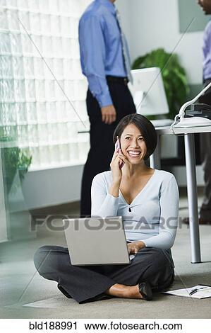 Stock Image - Japanese businesswoman working on office floor. Fotosearch