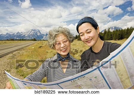 Stock Photography - Japanese mother and daughter looking at map. Fotosearch