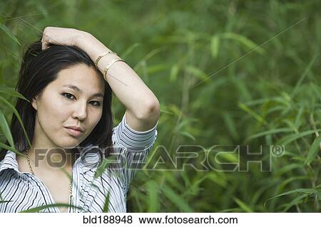 Stock Photo - Japanese woman outdoors with head in hands. Fotosearch