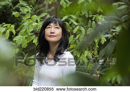 Stock Photography - Japanese woman sitting in garden. Fotosearch
