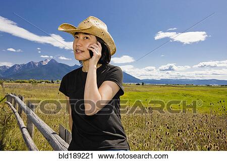 Japanese woman talking on cell phone in country field View Large Photo Image Stock Image - Japanese woman talking on cell phone in country field. Fotosearch