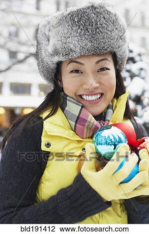 Stock Image - Korean woman carrying Christmas ornaments. Fotosearch