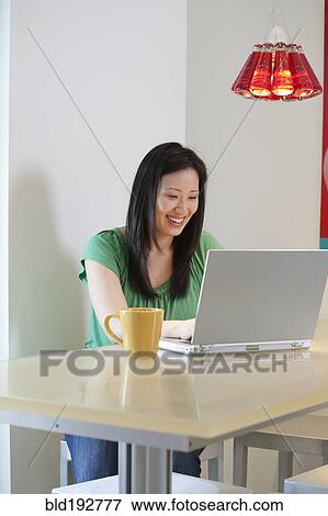 Korean woman typing on laptop View Large Photo Image Stock Photo - Korean woman typing on laptop. Fotosearch