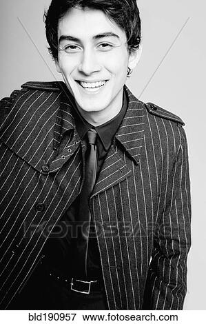 Stock Photo - Laughing mixed race man in fashionable coat. Fotosearch