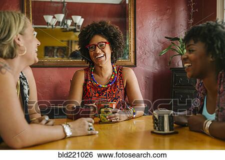 Stock Photograph - Laughing women drinking coffee. Fotosearch
