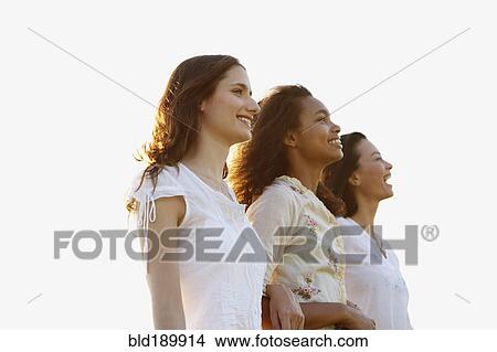 Low angle view of three women standing arm in arm View Large Photo Image Picture - Low angle view of three women standing arm in arm. Fotosearch