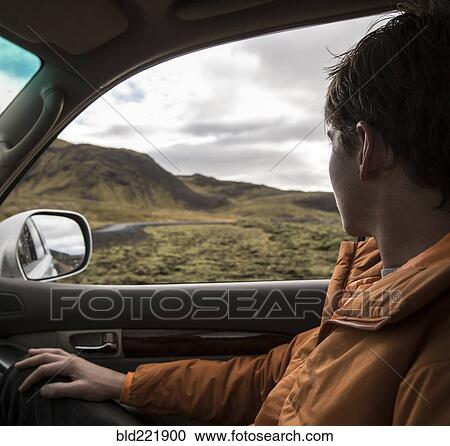 Stock Image - Man driving in remote landscape. Fotosearch