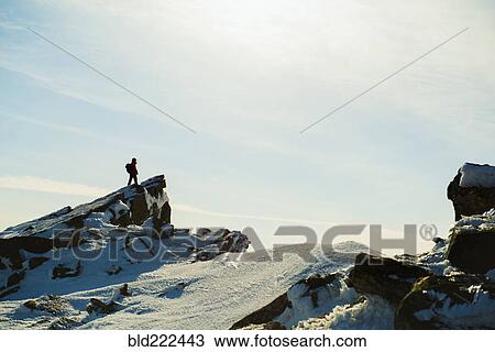 Stock Image - Man hiking on mountain in winter. Fotosearch
