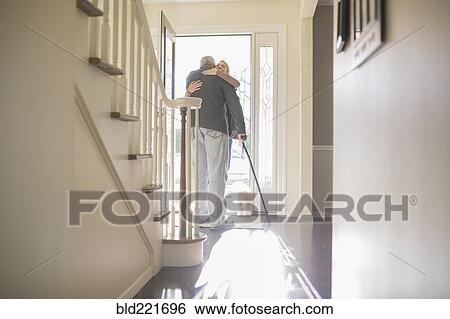 Man hugging visitor in front door View Large Photo Image Stock Photograph - Man hugging visitor in front door. Fotosearch