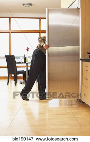 Stock Photo - Man looking in refrigerator. Fotosearch
