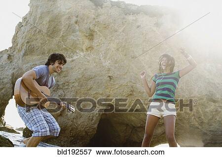 Man playing guitar for girlfriend on beach View Large Photo Image Stock Photo - Man playing guitar for girlfriend on beach. Fotosearch