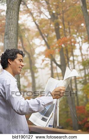 Stock Photo - Man reading newspaper outdoors. Fotosearch