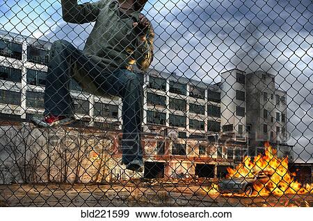 Man scaling wall in gritty urban neighborhood View Large Photo Image Stock Photo - Man scaling wall in gritty urban neighborhood. Fotosearch