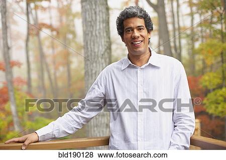 Man standing on deck in woods View Large Photo Image Stock Photo - Man standing on deck in woods. Fotosearch