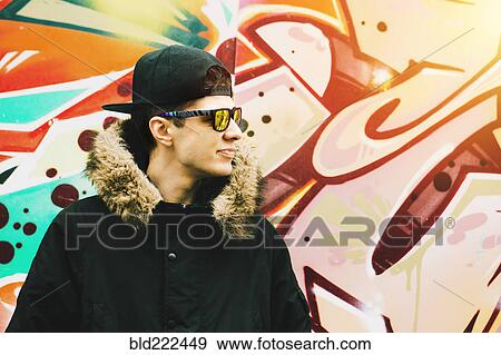 Stock Photo - Man wearing winter coat at graffiti wall. Fotosearch