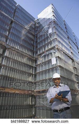 Stock Photo - Manager talking with worker at processing plant. Fotosearch