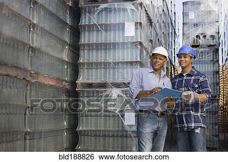 Stock Photograph - Manager talking with worker at processing plant. Fotosearch