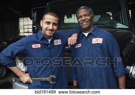 Stock Photo - Mechanics standing in repair shop. Fotosearch