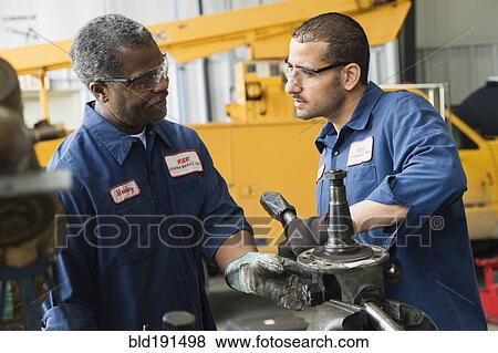 Stock Photo - Mechanics working together. Fotosearch