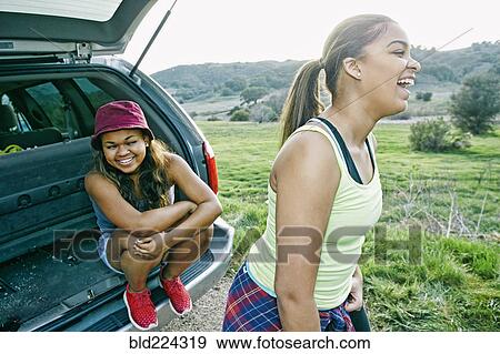 Mixed Race at hatch of car laughing View Large Photo Image Stock Photo - Mixed Race at hatch of car laughing. Fotosearch